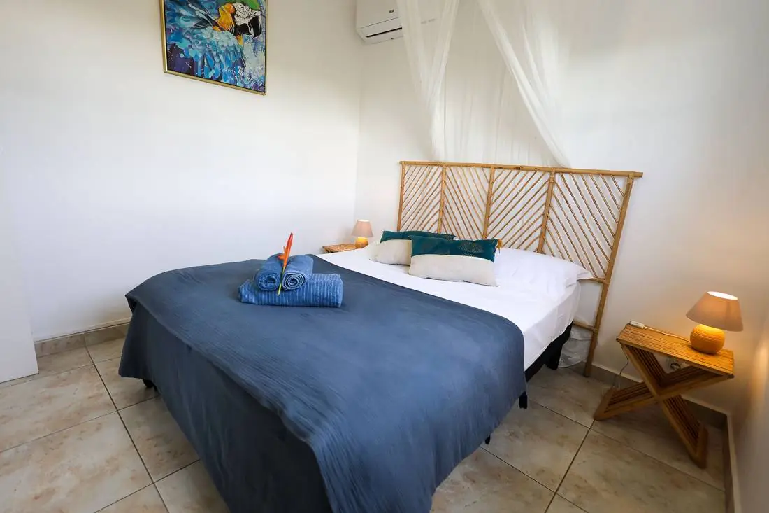Chambre 1 de la Villa Trézel : lit double, climatisation et moustiquaire