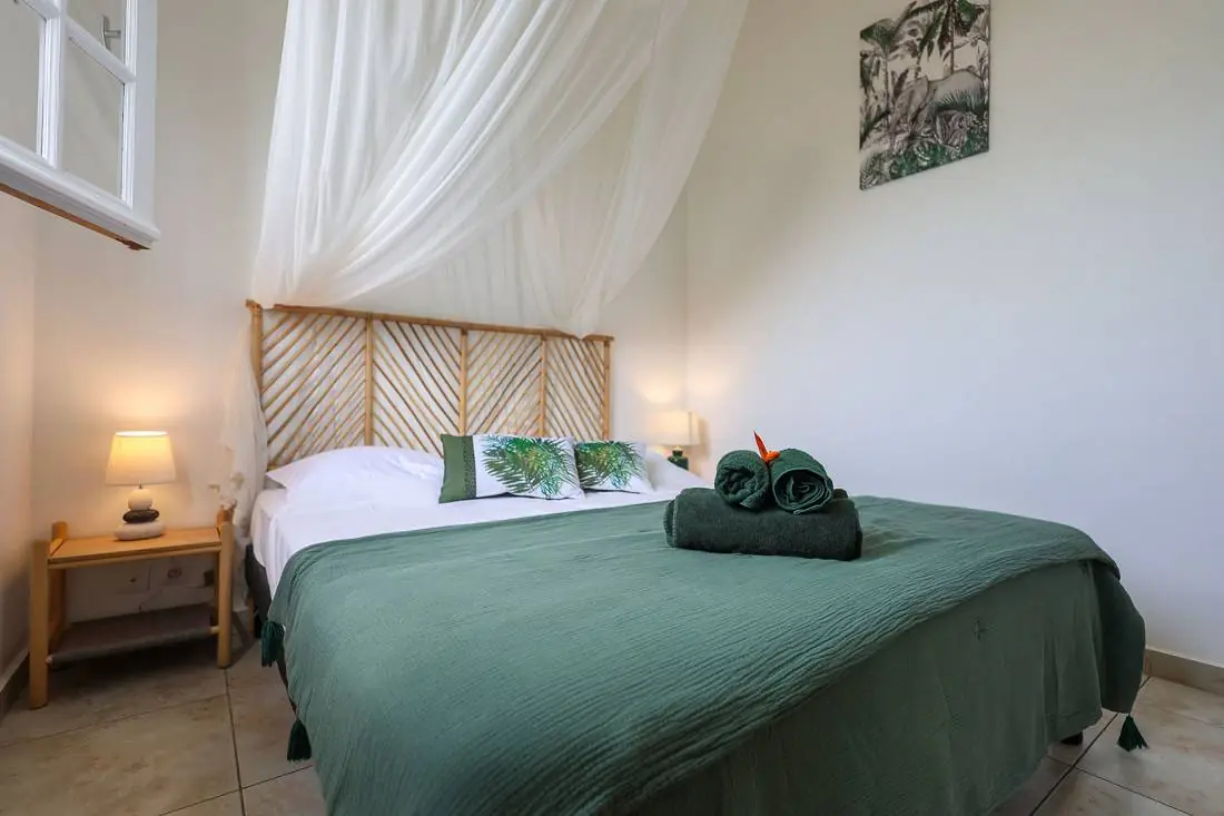 Chambre avec lit double, moustiquaire et lampes de chevet