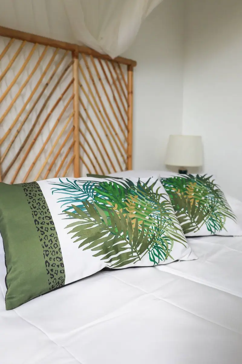 Lit avec coussins à motifs tropicaux
