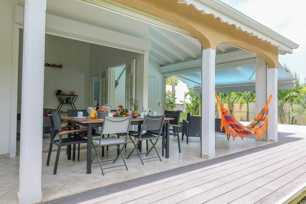 Terrasse couverte avec table de repas et hamacs